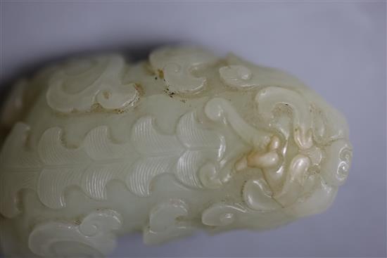 A Chinese pale celadon jade figure of lion-dog, bixi, 17th century, L. 6.8cm, wood stand